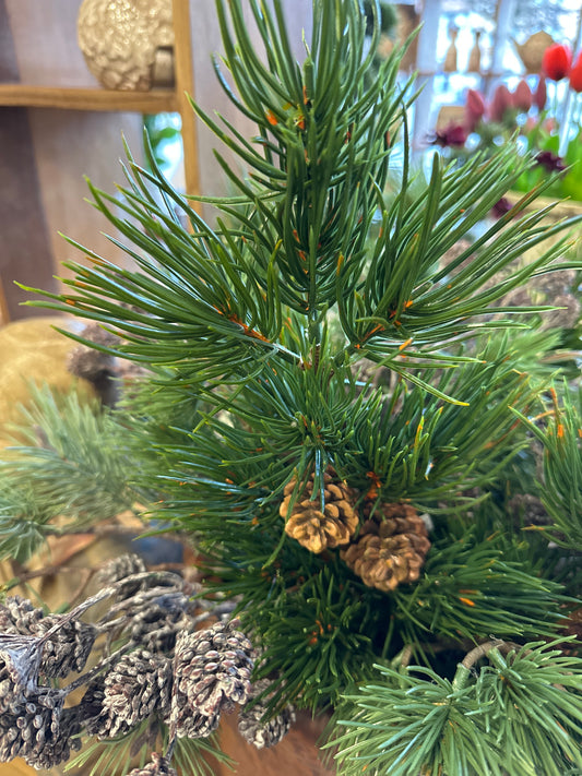 Grüner Kunst Zweig mit zwei Zapfen